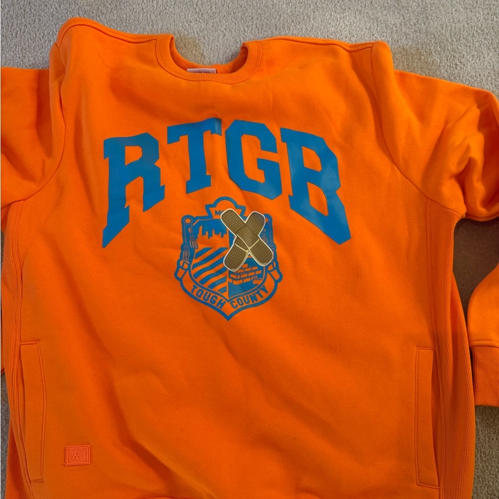 Orange men’s sweatshirt with bold blue letters